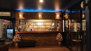a bar in a restaurant with a brick wall at Foresto Sukhothai Guesthome in Sukhothai