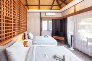a hotel room with two beds and a television at Hi Blue Bali Melasti Resort in Karangasem