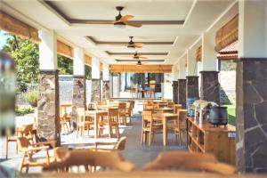 a restaurant with wooden chairs and tables on a patio at Hi Blue Bali Melasti Resort in Karangasem