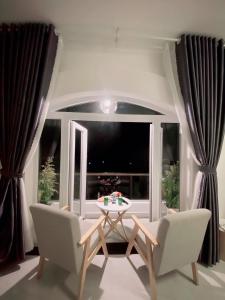 sala de estar con mesa, sillas y ventana en Greenview Dalat en Dalat