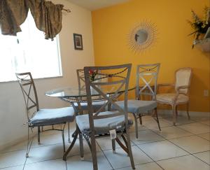 a dining room with a glass table and chairs at Charming Kendall Home in Kendall