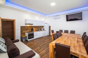 a living room with a table and a kitchen at Group Holiday Accommodation Natura Croatia, Sleeps Up To 13 People in Maslenica