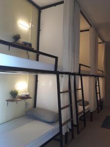 a room with three bunk beds and a ladder at MOHO in Moalboal