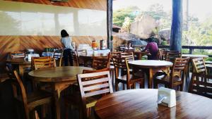 a restaurant with wooden tables and people sitting at tables at Palmsuay Resort in Ban Dong Klang