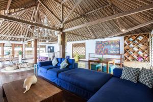 a living room with a blue couch and a table at Villa GMB Beach house in Uluwatu