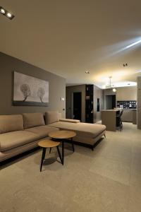 a living room with a couch and tables in it at Sofia Apartments in Cluj-Napoca