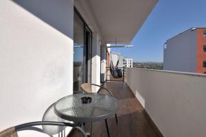 a glass table on the balcony of a building at Sofia Apartments in Cluj-Napoca