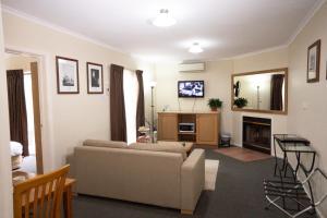 a living room with a couch and a fireplace at Admiralty Inn in Geelong