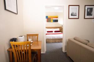 een kamer met een tafel en een slaapkamer met een bed bij Admiralty Inn in Geelong
