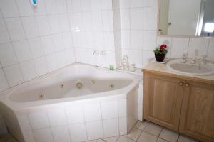 吉朗的住宿－Admiralty Inn，白色的浴室设有浴缸和水槽。