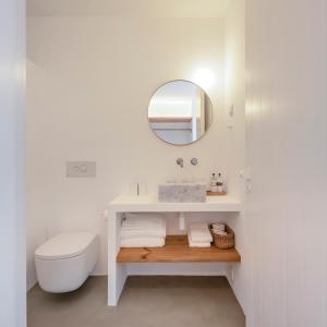 Baño blanco con aseo y espejo en Casas Caiadas | Open House, en Arraiolos