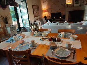 einem Esstisch mit Schalen und Tellern darauf in der Unterkunft Le Vieux Logis de la Galocherie in Sainte-Florence