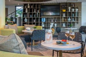 a restaurant with two tables and chairs with wine glasses at ibis Styles Pertuis Portes du Luberon in Pertuis