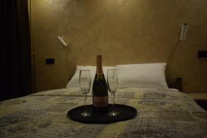 a bottle of wine and two glasses on a bed at Hotel "Srbija Tis" in Zaječar