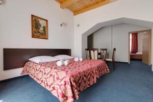 a bedroom with a large bed with a red blanket at Apartamenty Renesans in Krynica Zdrój