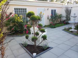 einen Garten mit einer weißen Bank und ein paar Blumen in der Unterkunft Ferienwohnanlage Majorcas in Dahme