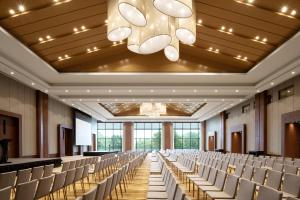 a large room with rows of chairs and a chandelier at New World Qingyuan Hotel -formerly KHOS QINGYUAN in Qingyuan