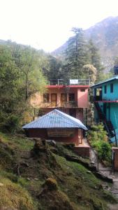um edifício com um telhado azul numa colina em Kamal Guest House em McLeod Ganj