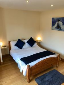 a bedroom with a bed with blue pillows on it at Oak Trees Corner stylish , relaxing , getaway in Wicklow