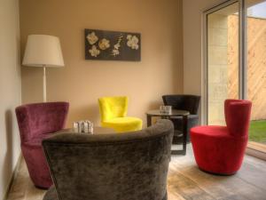 una sala de espera con sillas coloridas y una mesa en Chateau La France, en Beychac-et-Caillau