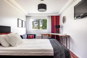 Hotel Käenpesä في يليفيسكا: غرفة نوم بسرير وطاولة ونافذة