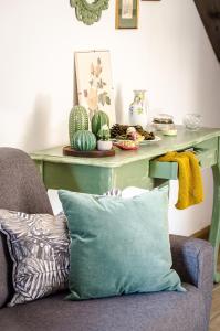 kanapę z poduszką przed stołem z kaktusem w obiekcie AnMa Cottages The Secret Garden w mieście Pianello Del Lario