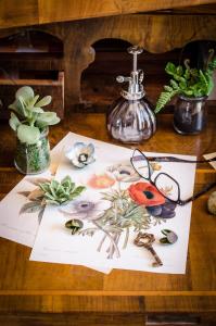 stół z obrazem kwiatów i okularów w obiekcie AnMa Cottages The Secret Garden w mieście Pianello Del Lario