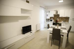 a kitchen and dining room with a table and a tv at Lar Apartment in Focşani