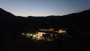 una casa iluminada por la noche con luces en Agriturismo la vallata, en Masseria Scilva