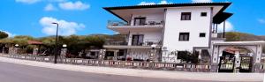 a white building on the side of a street at House Anna Houhlia in Vourvourou