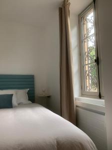 ein Schlafzimmer mit einem Bett und einem Fenster in der Unterkunft Appartement Scandinave dans domaine historique d'exception in Vernaison + 14 Fotos