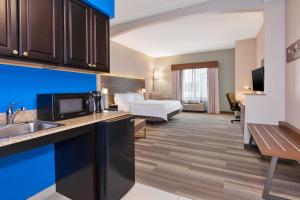 a hotel room with a bed and a kitchen at Holiday Inn Express Hotel & Suites Warminster-Horsham by IHG in Warminster