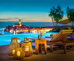 a patio with a table and chairs next to a pool at Grand Park Hotel Rovinj by Maistra Collection in Rovinj