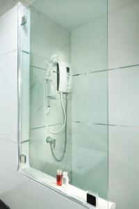 um chuveiro na casa de banho com um espelho em B Hotel em Khon Kaen