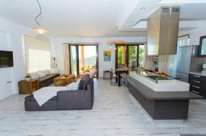 a kitchen and living room with a couch and a table at Amaryllis House in Parga