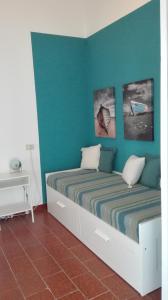 a bedroom with two beds and a blue wall at Retrò Rooms in Cefalù