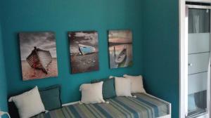 a blue wall with four pictures of boats on it at Retrò Rooms in Cefalù