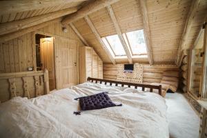 a bedroom with a bed in a wooden cabin at Cabane- Vila Crinul si Teodor Poiana Brasov in Poiana Brasov