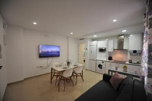 カディスにあるCentrico Playa Caleta 3 dormitoriosのリビングルーム(ソファ、テーブル付)、キッチンが備わります。