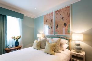 a bedroom with a large white bed with pillows at Roslin Beach Hotel in Southend-on-Sea