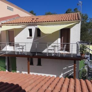 una gran terraza con sillas y una sombrilla en una casa en Le Transat en Palavas-les-Flots