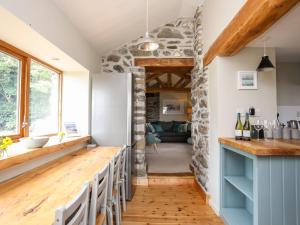 a kitchen with a bar and a living room at Ty Cerrig in Gaerwen