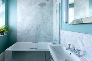 a white bathroom with a sink and a mirror at Roslin Beach Hotel in Southend-on-Sea