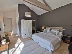 a bedroom with a large bed and a white cabinet at Les Vieilles Pierres chambres d'hôtes in Ognon