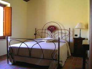 a bedroom with a bed with a metal frame at Agriturismo La Cicala in Carassai
