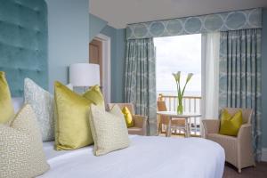 a bedroom with a white bed with yellow pillows at Roslin Beach Hotel in Southend-on-Sea