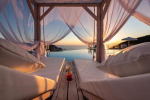 two beds on a boat with a view of the ocean at Petani Bay Hotel - Adults Only in Vóvikes