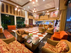 een grote lobby met banken en stoelen en een tafel bij East Inn 15 Rayong - SHA Certified in Rayong