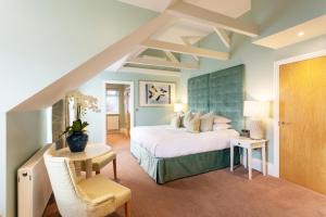 a bedroom with a king sized bed and a chair at Roslin Beach Hotel in Southend-on-Sea