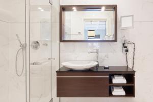 La salle de bains est pourvue d'un lavabo et d'une douche. dans l'établissement Boutique Hotel Notting Hill, à Amsterdam